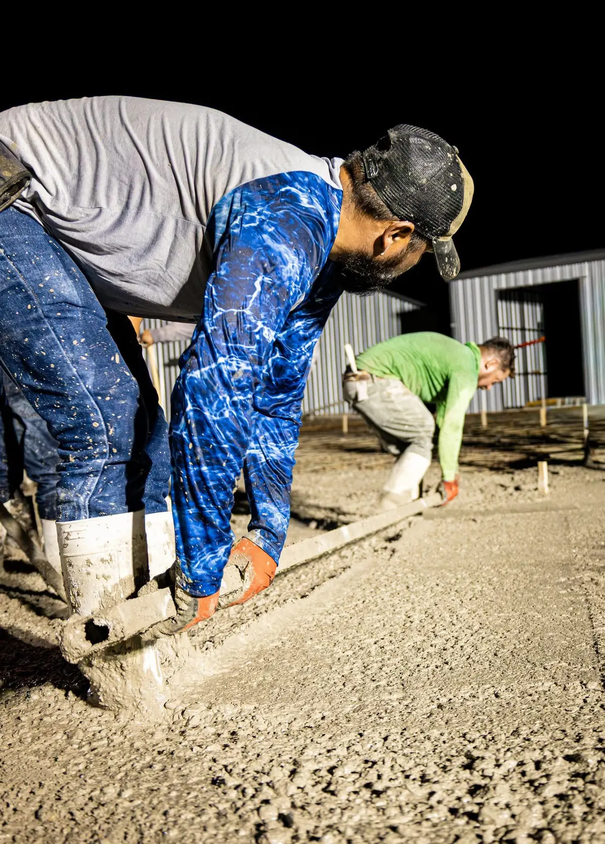 Western Star Concrete crew hand finishing a commercial concrete slab at night